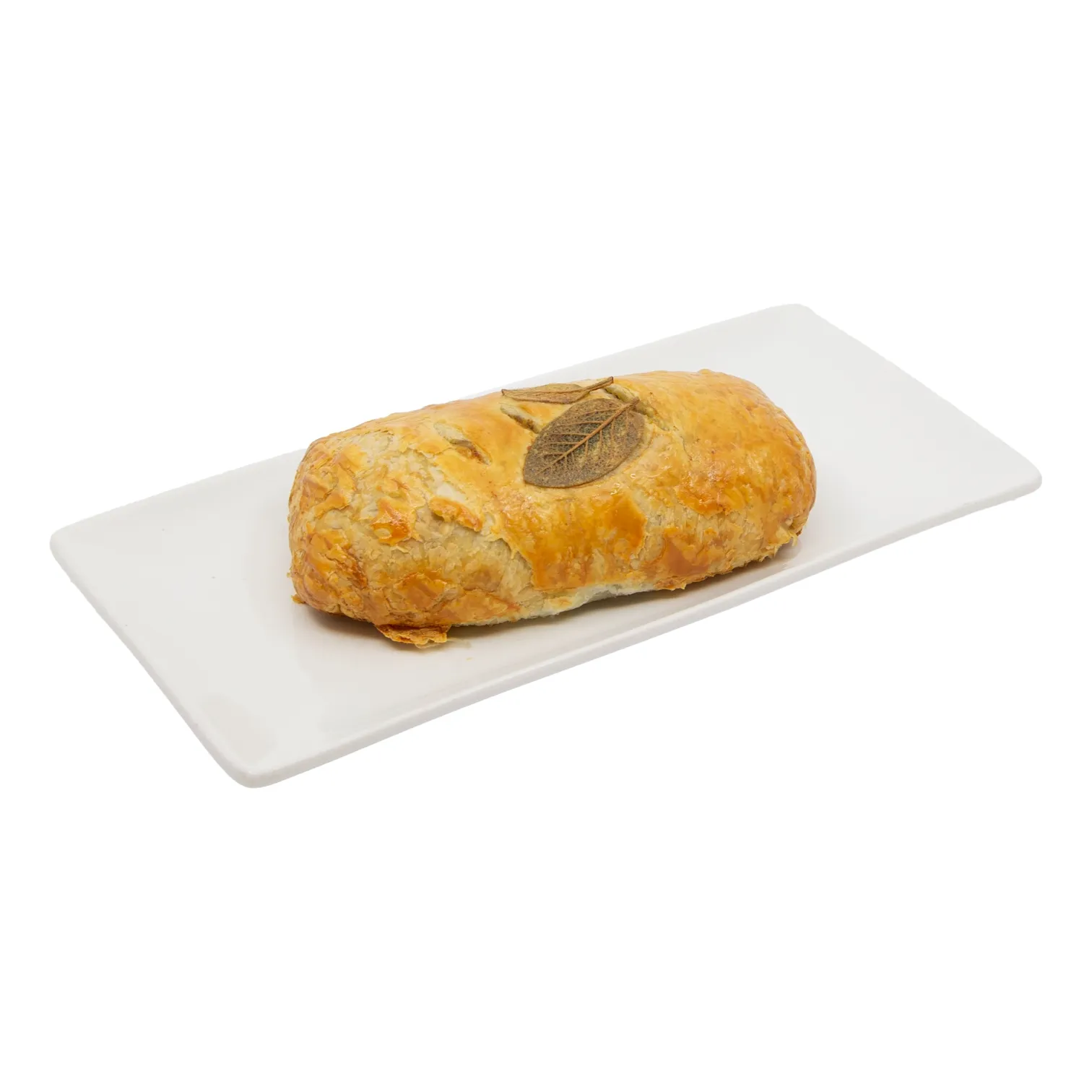 Golden-brown puff pastry with a crisp, flaky crust and decorative leaf on top, served on a white platter.