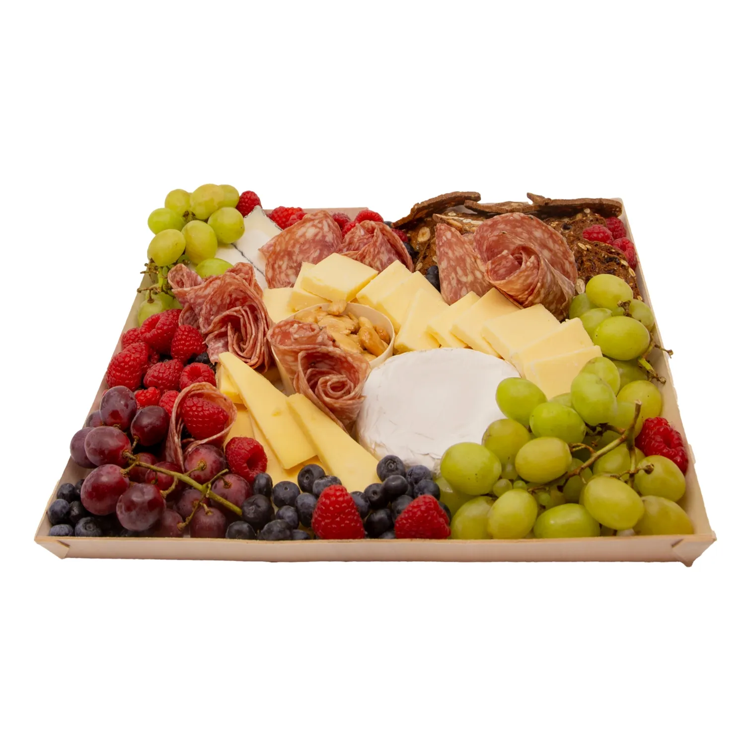 A festive charcuterie board on a wooden tray features folded cured meats, sliced cheeses, a soft white cheese, green and purple grapes, berries, and crackers.
