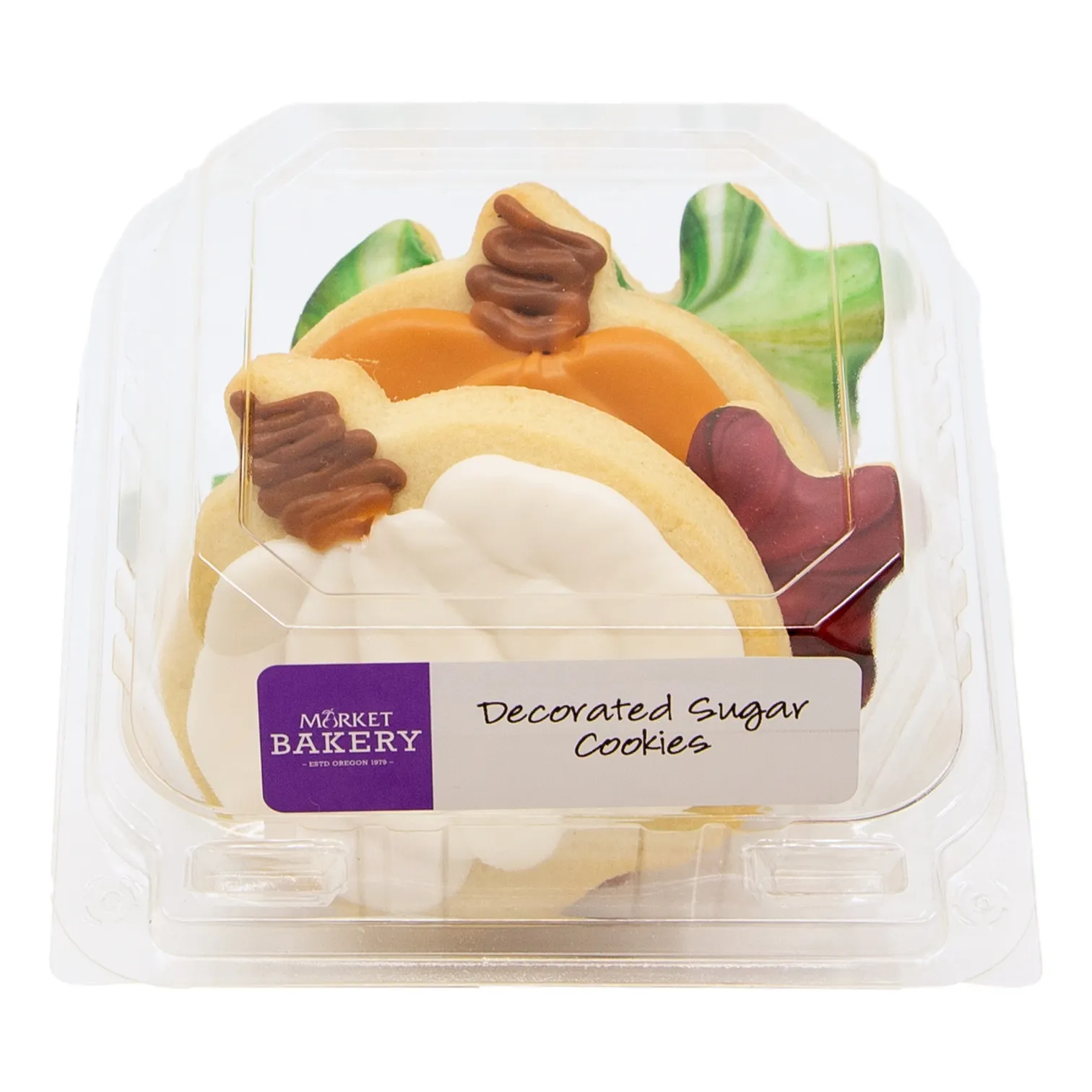 A clear plastic package holds colorful decorated sugar cookies shaped like fruit, leaves, and swirls. A Market Bakery label sits on the front.