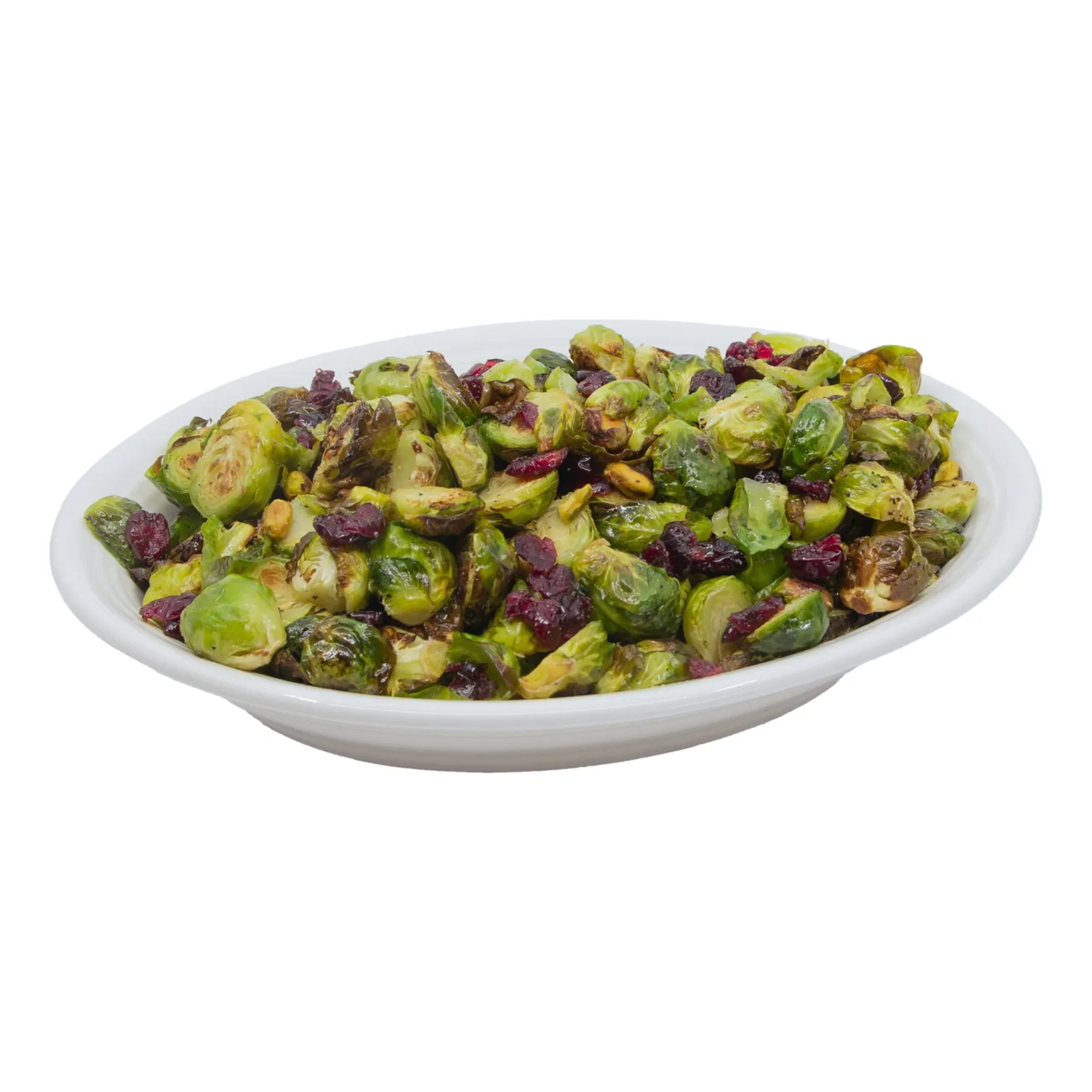 A white oval bowl holds roasted Brussels sprouts tossed with dried cranberries and chopped nuts, creating a colorful, appetizing side dish.