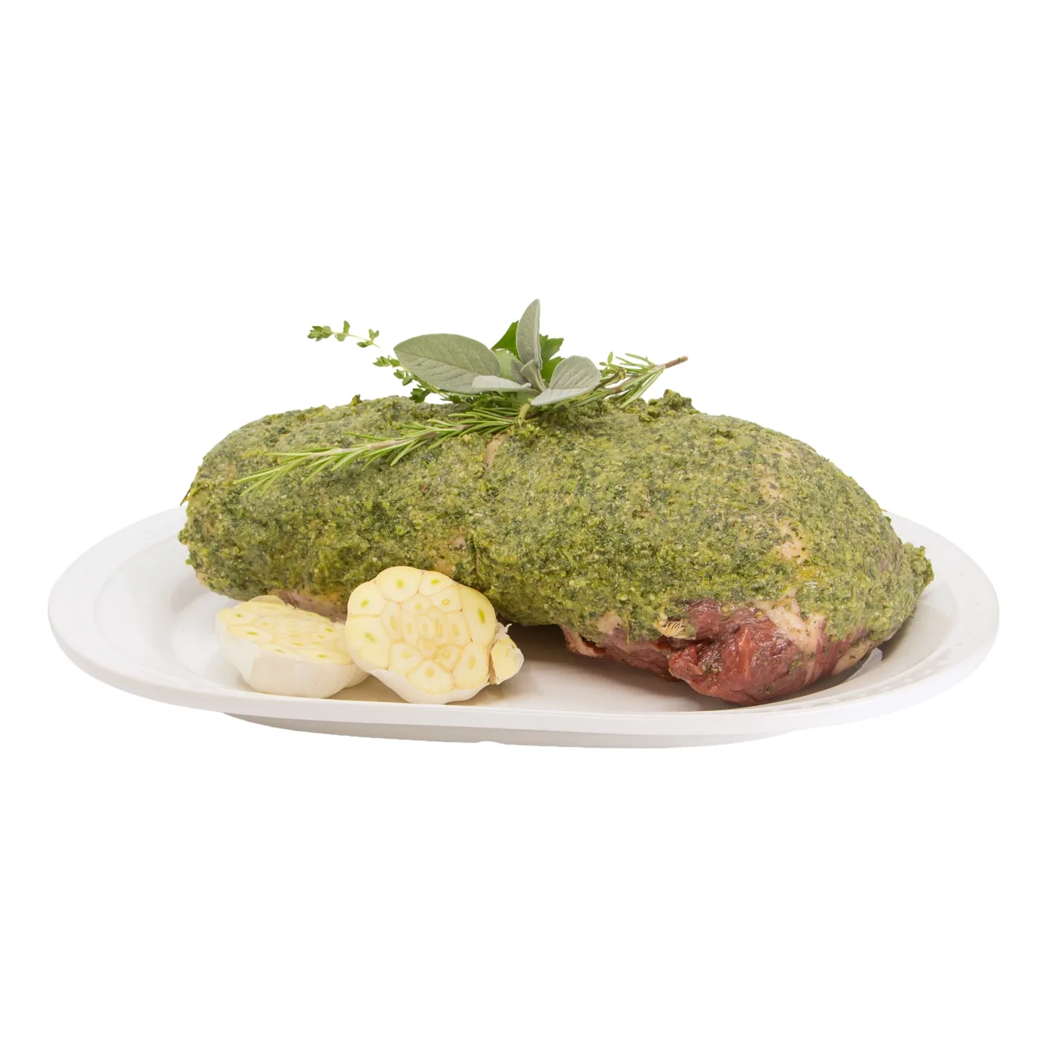 A green herb-crusted, stuffed, boneless leg of lamb rests on a white plate, garnished with fresh herbs and served with sliced root vegetables; an appetizing, rustic presentation.
