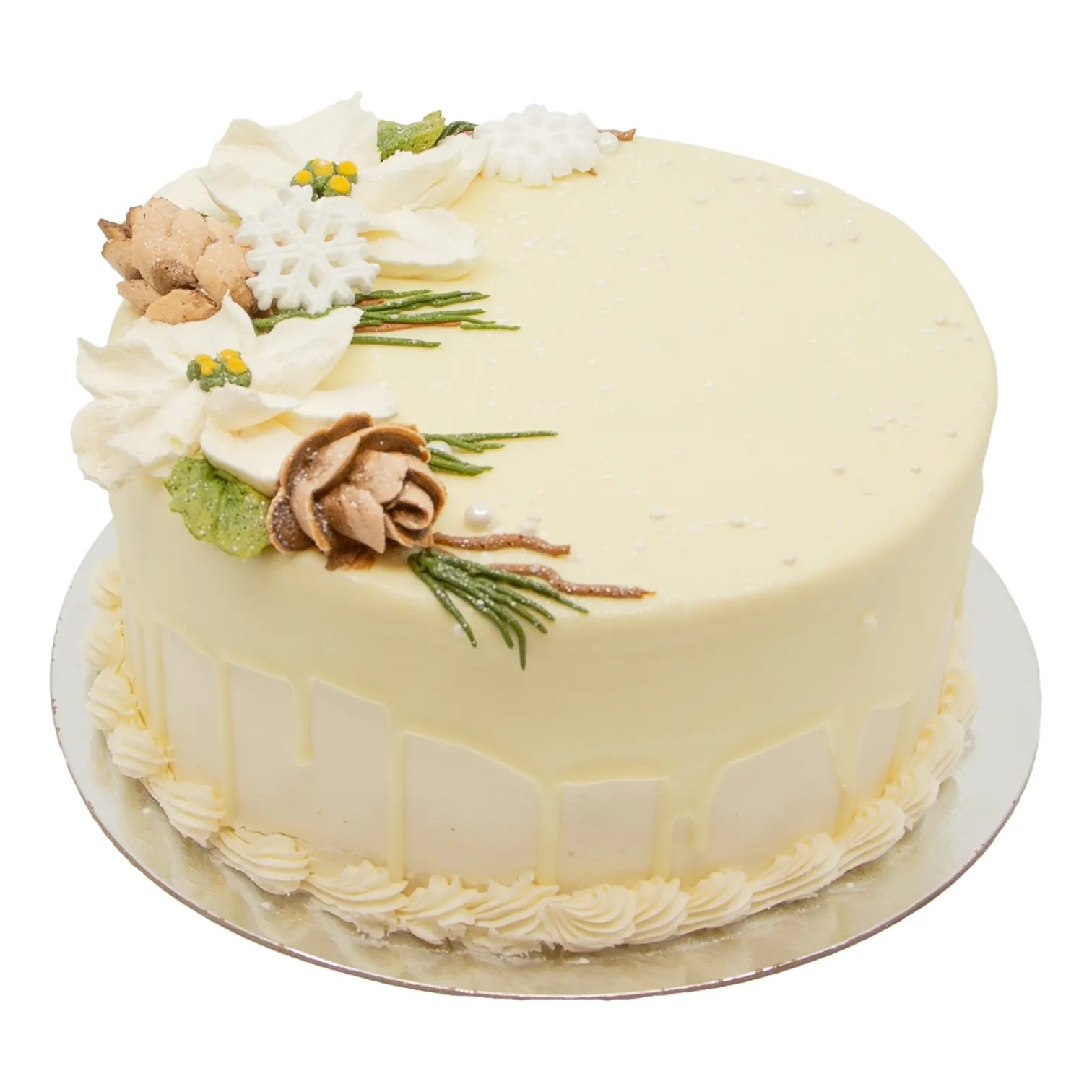 Round pale-cream frosted cake on a silver board, decorated with piped borders, edible flowers, herbs, and curled chocolate. Elegant, festive presentation.