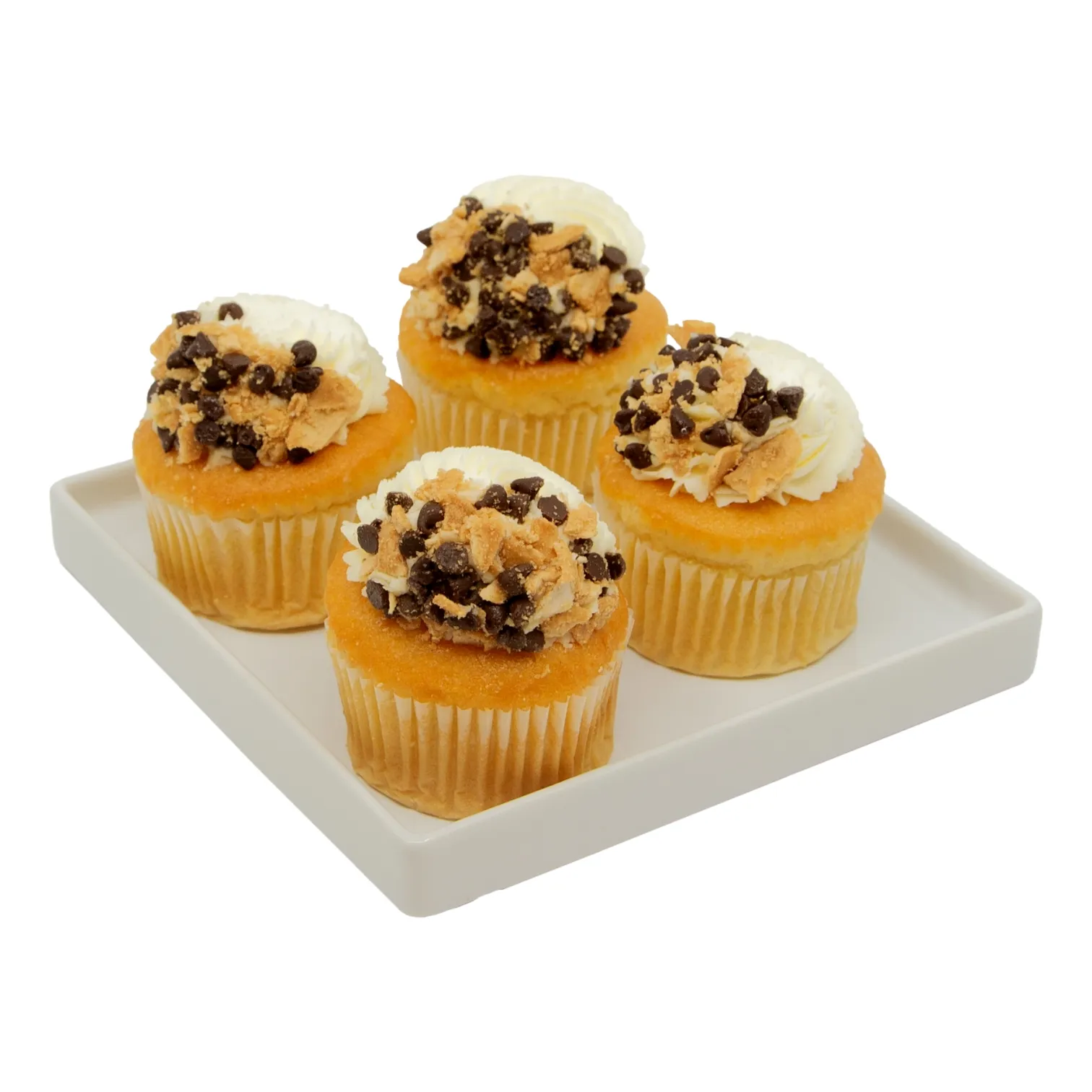 Four golden cupcakes topped with cannoli filling, chocolate chips, and cannoli shell pieces sit on a white platte.