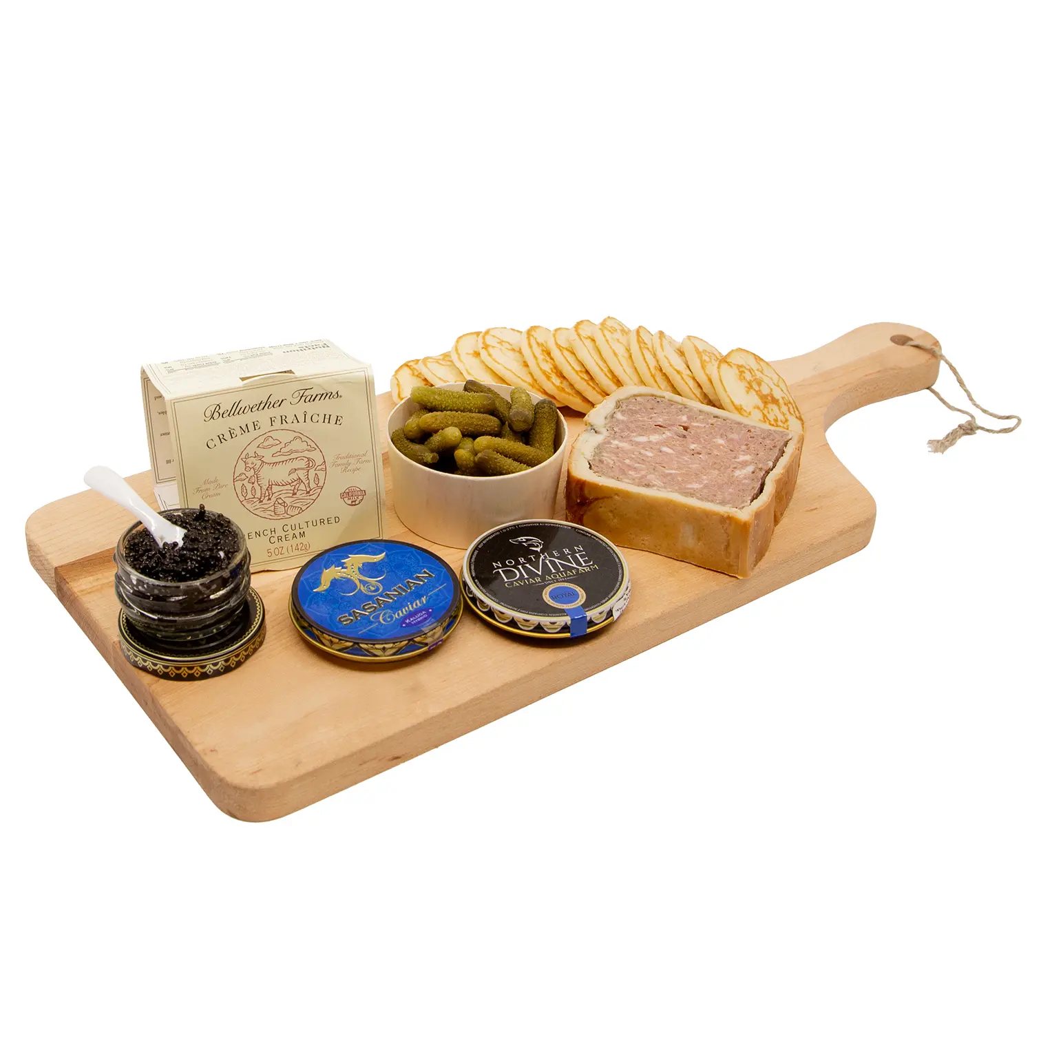 A wooden serving board displays terrine in a pastry crust, sliced bread, pickles, caviar jars, and a pâté box, arranged like an elegant appetizer spread.