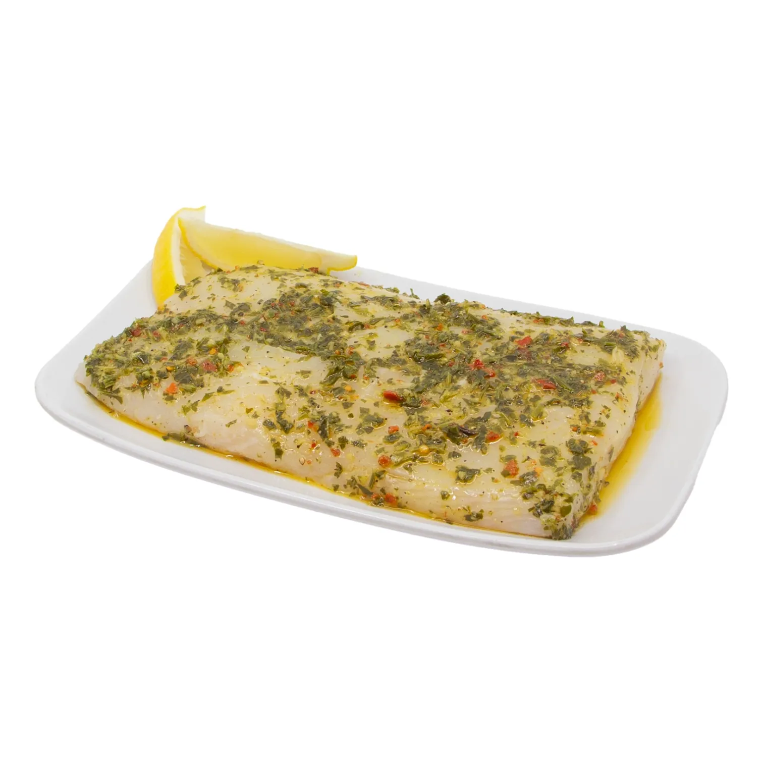 Chimichurri seasoned halibut fillet with chopped herbs and red pepper, on a white platter with a lemon wedge.