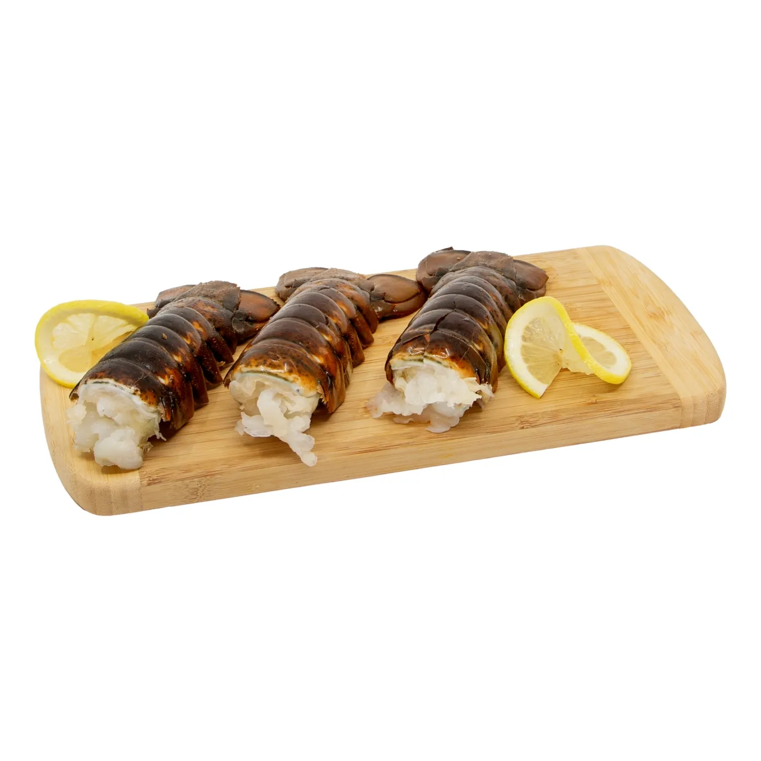 Three lobsters tails with white meat showing rest on a wooden board beside lemon slices, making an appetizing seafood display.