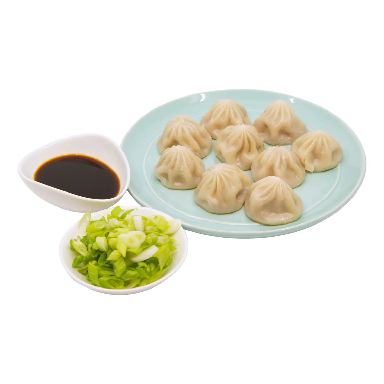 A plate of steamed dumplings sits with dark dipping sauce and chopped green onions.