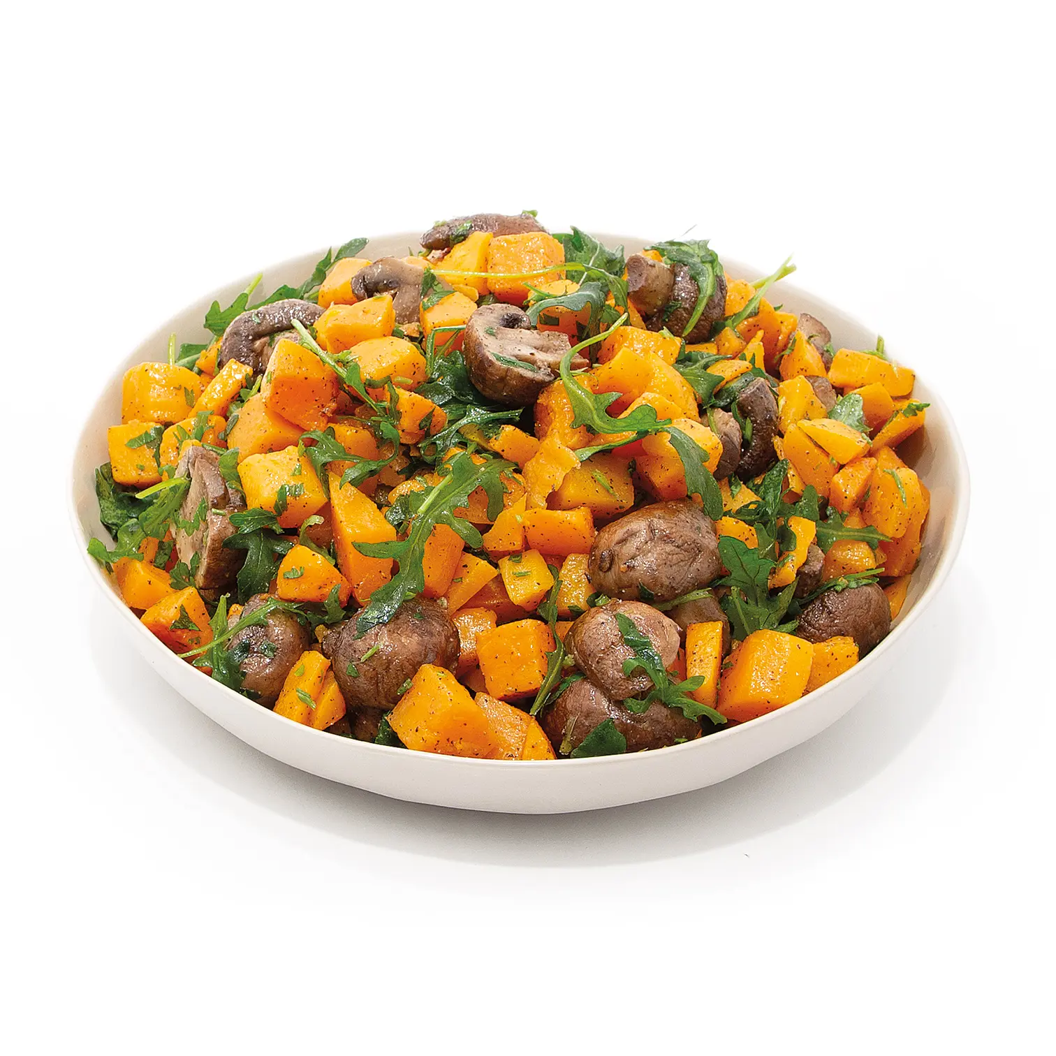 A white bowl piled with roasted butternut squash cubes, brown mushrooms, and fresh arugula.